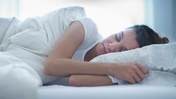 Eine Frau liegt im Bett und schläft entspannt