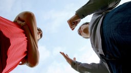 Symbolbild zu Diskussionskultur: zwei Menschen diskutieren in konfrontativer Körperhaltung