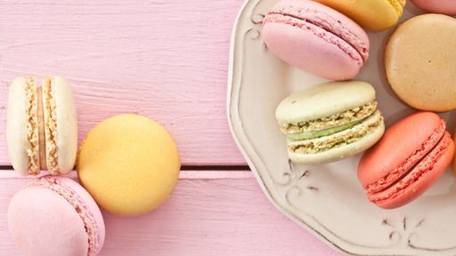 Bunte französische Macarons liegen auf einem vintage Teller.