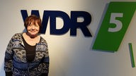 Anka Zink steht vor dem WDR5-Logo.