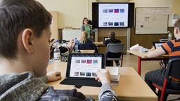 Schüler sitzt im Unterricht vor einem iPad