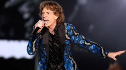 Mick Jagger mit Mikrofon in der Hand auf der Bühne. 