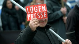 Ein Mann zeigt in Rathenow (Brandenburg) dem Fotografen ein Schild mit der Aufschrift "Lügenpresse", 05.03.2016. 