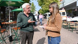 Lokaljournalistin interviewt einen Mann in Petershagen, Nordrhein-Westfalen.