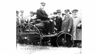 Carl Benz auf seinem seinem Dreiradwagen