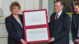 Bodo Ramelow und Birgit Diezel zeigen das "Gedenkblatt" zum Festakt 100 Jahre Weimarer Verfassung
