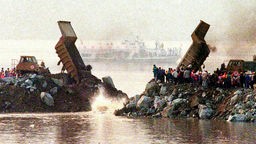 Lastwagen kippen am 8.11.1997 die letzten Felsbrocken in den Jangtse-Fluß. China hat den Jangtse-Fluß für den Bau des weltweit größten Wasserkraftwerkes gesperrt. Damit beginnt die zweite und schwierigste Bauphase des umstrittenen Staudammes. 