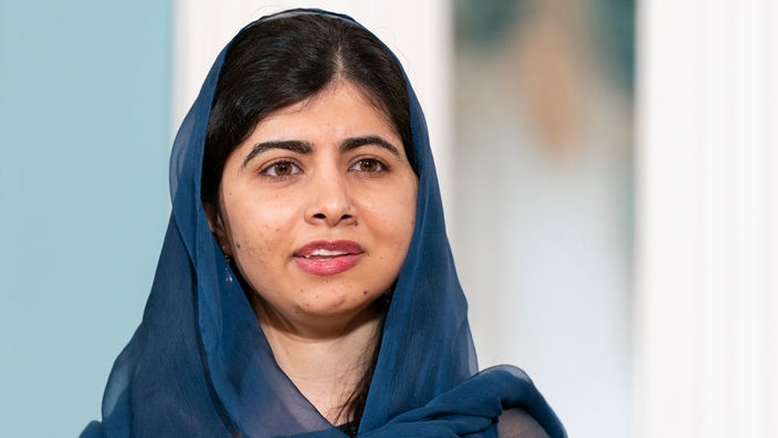 Aufnahme zeigt Malala Yousafzai, eine junge Frau, sie trägt ein dunkelblaues Tuch locker über ihren dunklen Haaren