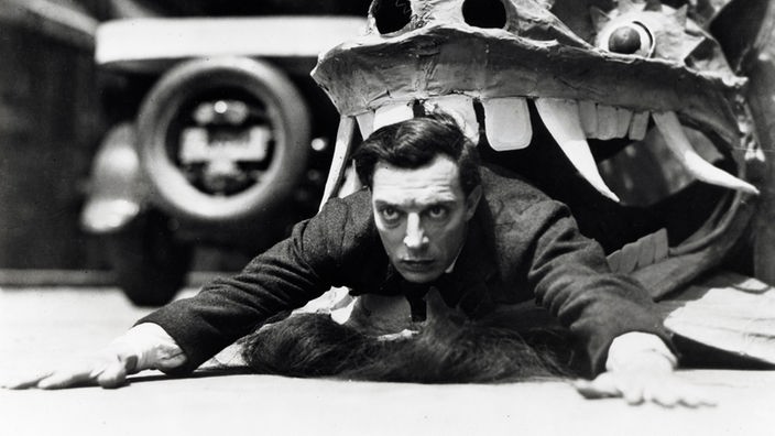 Der US-amerikanische Schauspieler Buster Keaton (1895 - 1966) als Opfer einer chinesischen Drachenfigur. 