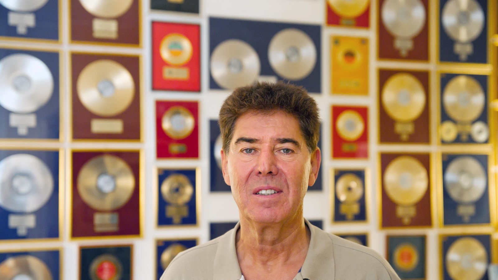 Musikproduzent Jack White in seinem Unternehmens in Berlin vor einer Wand mit Schallplatten-Preisen