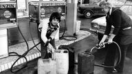 Archiv: Eine Frau und ein Junge füllen am 7.11.1973 an einer Tankstelle Benzinkanister mit Treibstoff