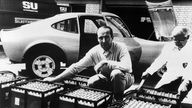 Georg von Opel mit sechs Batterie-Trögen vor Opel GT