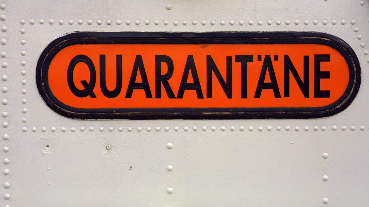 Schild mit der Aufschrift 'Quarantäne' auf einer Tür