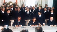 Der deutsche Bundeskanzler Willy Brandt (l.) und der sowjetische Ministerpräsident Alexei Kossygin (M.) unterzeichnen am 12.8.1970 in Moskau den Deutsch-Sowjetischen Vertrag, rechts der sowjetische Außenminister Andrei Gromyko, hinter Brandt der Generalsekretär der KPdSU, Leonid Breschnew, rechts daneben Staatssekretär Egon Bahr