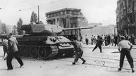 Demonstranten werfen am 17.06.1953 in Berlin mit Steinen nach russischen Panzern 
