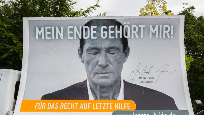 Ein Lkw transportiert ein Transparent mit dem Schriftzug "Mein Ende gehört mir" und dem Bild von Schauspieler Michael Lesch