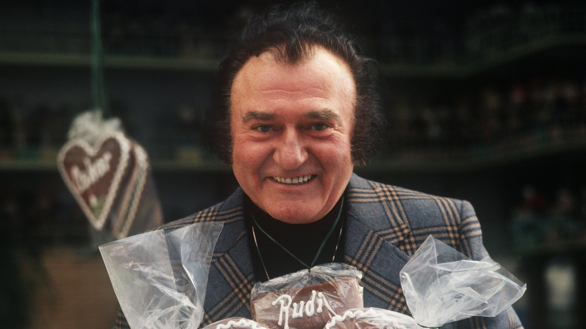 Schlagersänger Rudi Schuricke posiert mit Lebkuchenherzen. 