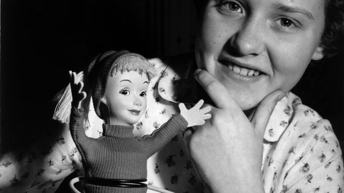 Eine kleine Puppe mit einem um die Hüften kreisenden Hula Hoop Reifen wird auf der Nürnberger Spielwarenmesse vom 22. bis 27.02.1959 vorgestellt