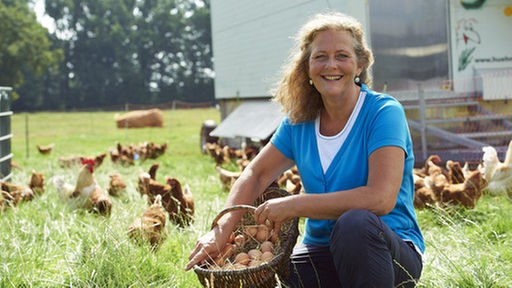 Barbara Büsch mit Eier-Korb in ihrem Garten