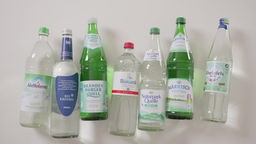 Sieben Glasflaschen mit Mineralwasser