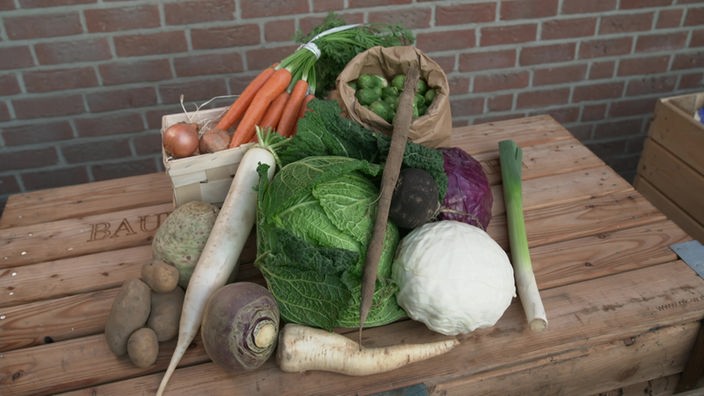 Das Bild zeigt verschiedene Gemüse sorten wie Möhren und Rosenkohl, die im Winter Saison haben.