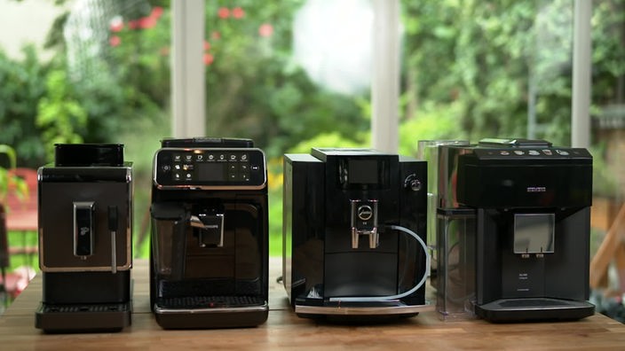 Das Bild zeigt vier verschiedene Kaffeevollautomaten von Siemens, Jura, Tchibo und Philips, die in der Sendung getestet werden.