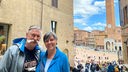 Petra und Rüdiger Erbslöh in den Gassen von Siena mit dem Piazza del Campo und dem Palazzo Pubblico im Hintergrund.