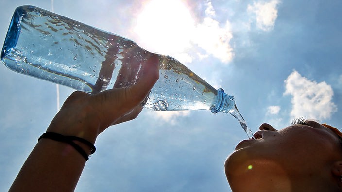 Eine Frau trinkt Wasser aus einer Flasche