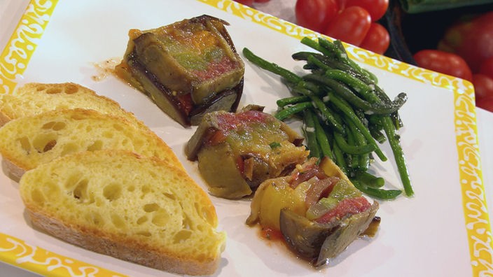 Tomatenterrine mit grünen Bohnen und Weißbrot auf einer Platte angerichtet