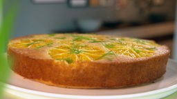 Ein Kuchen mit Orangenscheiben auf einem Teller.