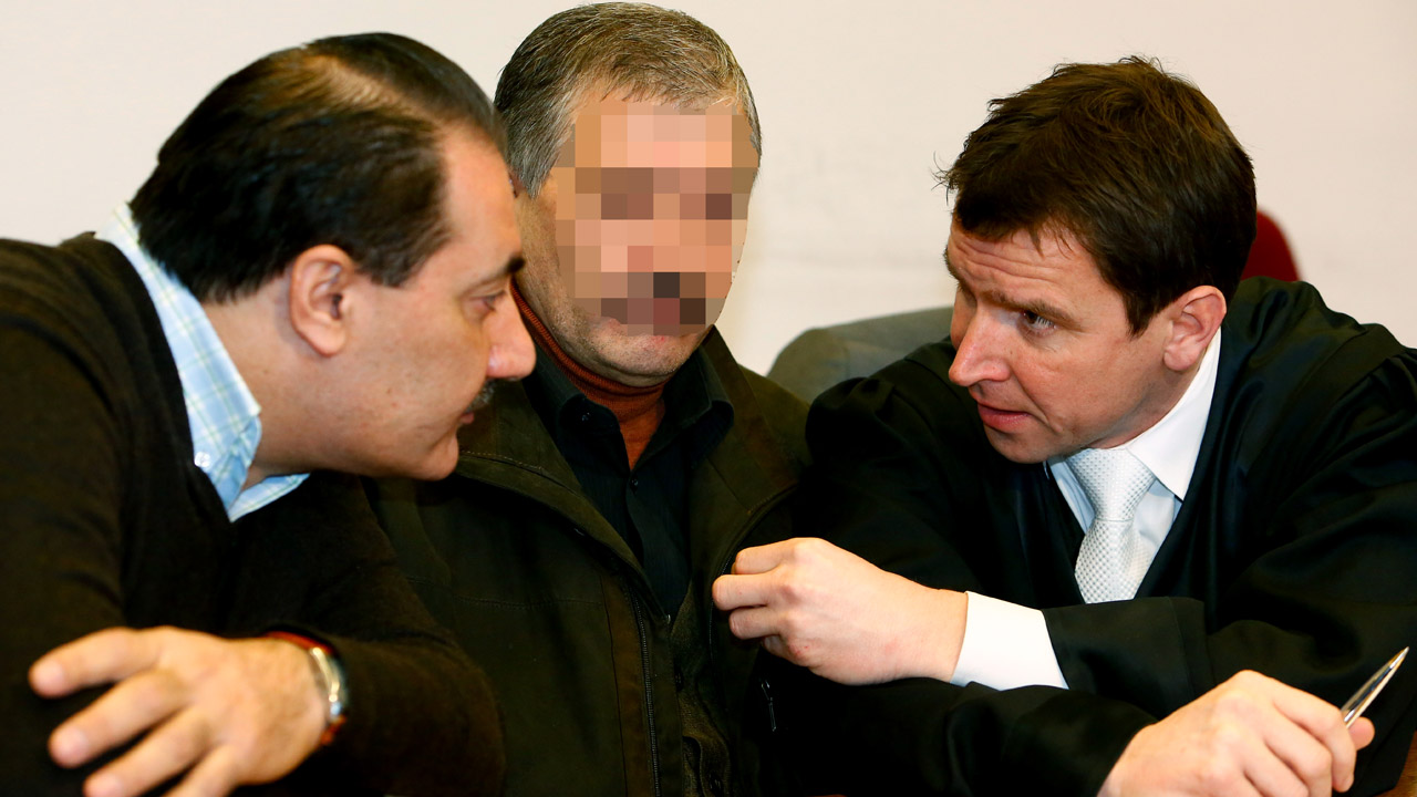 Der Vater der getoeteten Kurdin Arzu Ö. in einem Verhandlungssaal im Landgericht in Detmold zwischen seinem Anwalt und einem Dolmetscher