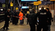 Polizisten stehen im Bahnhof in Bonn auf dem Bahnsteig