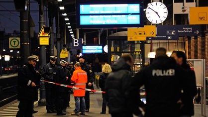 Polizisten stehen im Bahnhof in Bonn auf dem Bahnsteig