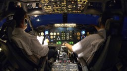 Zwei Piloten im Cockpit eines Flugzeug während eines Nachtflugs
