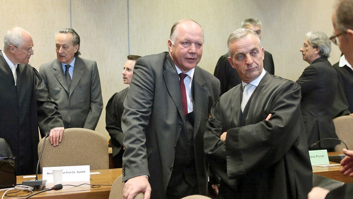 Die ehemaligen Banker (2.v.l.) Friedrich Carl Janssen, Matthias Graf von Krockow (M) und Dieter Pfundt (hinten rechts) warten am 27.02.2013 in Köln (Nordrhein-Westfalen) vor dem Landgericht zwischen ihren Anwälten auf den Prozessbeginn.