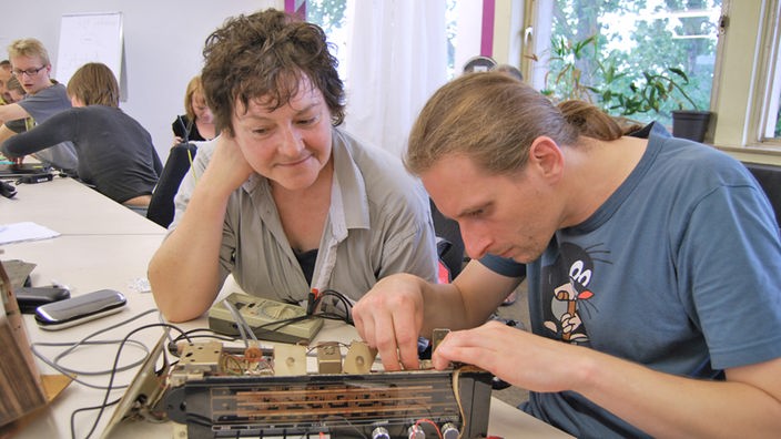 Jacek Wisniowski und Jutta Hippert reparieren ein Radio