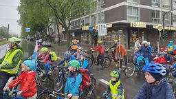 Demonstriende Kinder, Eltern und Lehrkräfte auf ihren Fahrrädern