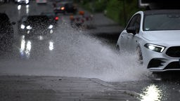 Köln: Ein Auto fährt durch eine große Wasserlach (02.05.2024)