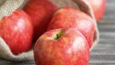  Äpfel im Jutesack. Bild: Apfel, rot, glänzend, auf Tisch liegend