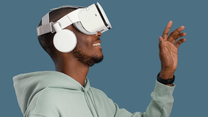 Ein Mann trägt eine Augmented-Reality-Brille mit großen Kopfhörern