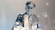 Abbildung eines Nationalsozialisten in Uniform auf einer Milchglasscheibe mit Durchblicken auf einen Ausstellungsraum