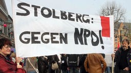 Gegendemonstranten in Stolberg halten ein Transparent