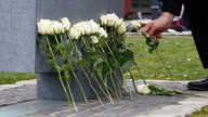 Am Mahnmal für die mutmaßlichen Opfer des NSU-Terrors legen Angehörige weiße Rosen nieder