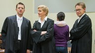 Die Angeklagte Beate Zschäpe (2.v.r.) steht am 19.11.2013 im Gerichtssaal in München zwischen ihren Anwälten Wolfgang Stahl (l.), Anja Sturm und Wolfgang Heer