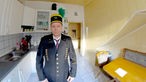 Der Steiger Andreas Schreiter steht in seiner Küche und trägt eine Traditionsuniform für Bergmänner