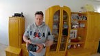 Andreas Schreiter steht in seinem Wohnzimmer und hält seinen ersten gewonnen Kohlebrocken in Händen