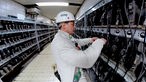 Der Steiger Andreas Schreiter holt in der Lampenhalle seine Grubenlampe mit Batterie aus dem Regal