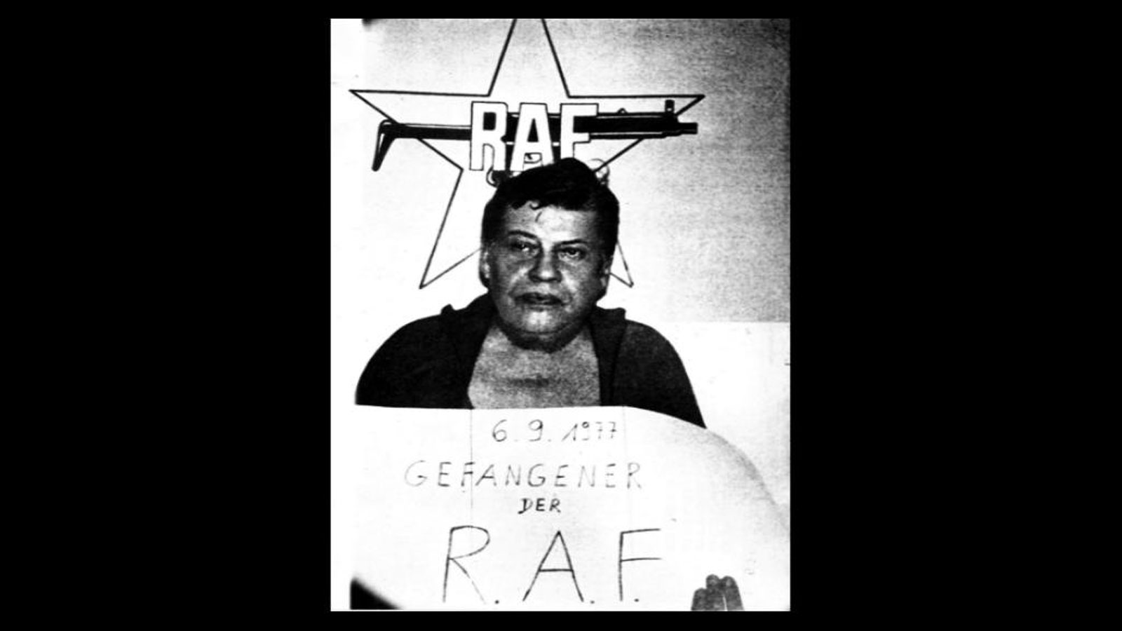 Hanns Martin Schleyer hält ein Schild mit der Aufschrift: 6.9.1977, Gefangener der RAF