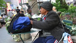 Die Obdachlose Jezabel sitzt auf einer Parkbank in New York
