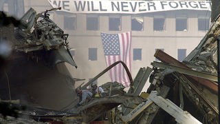 "Wir werden nie vergessen" steht auf einem Banner in der Nähe der WTC-Trümmer